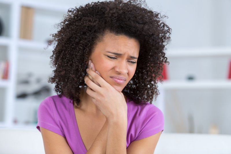 Close-up of a woman rubbing her jaw