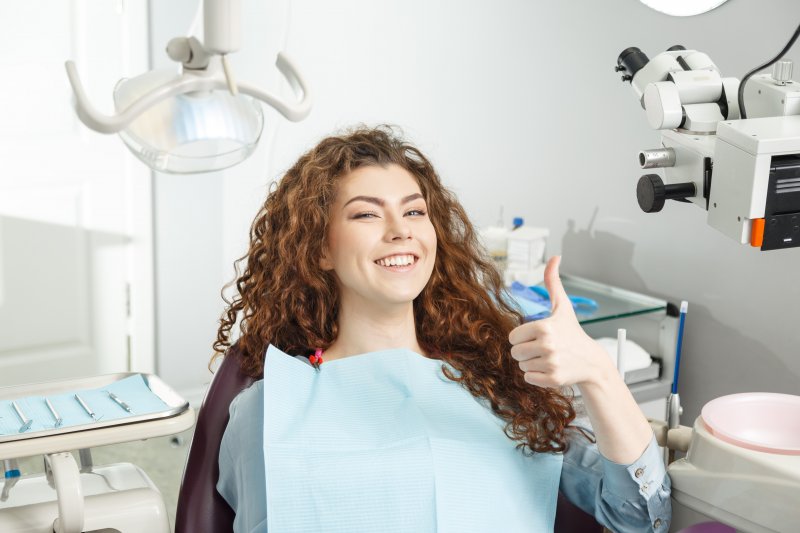 Female periodontal patient giving a thumbs up