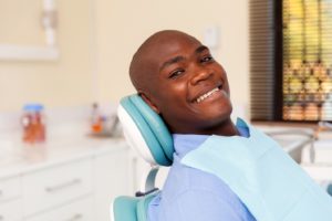 Man smiles after getting dental implants in Belmont